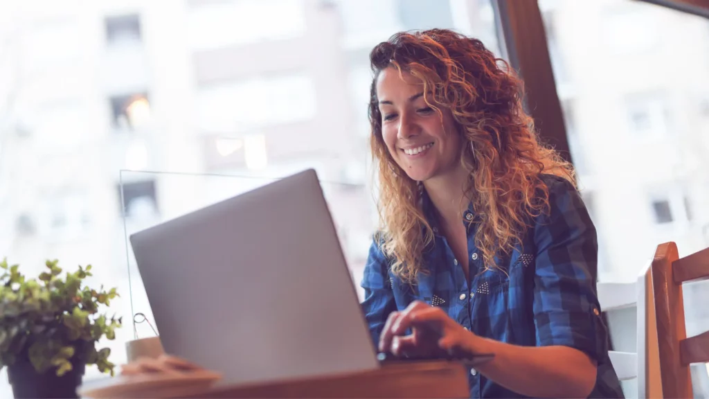 Une jeune femme travaillant à développer son business, assis à une table dans un café.