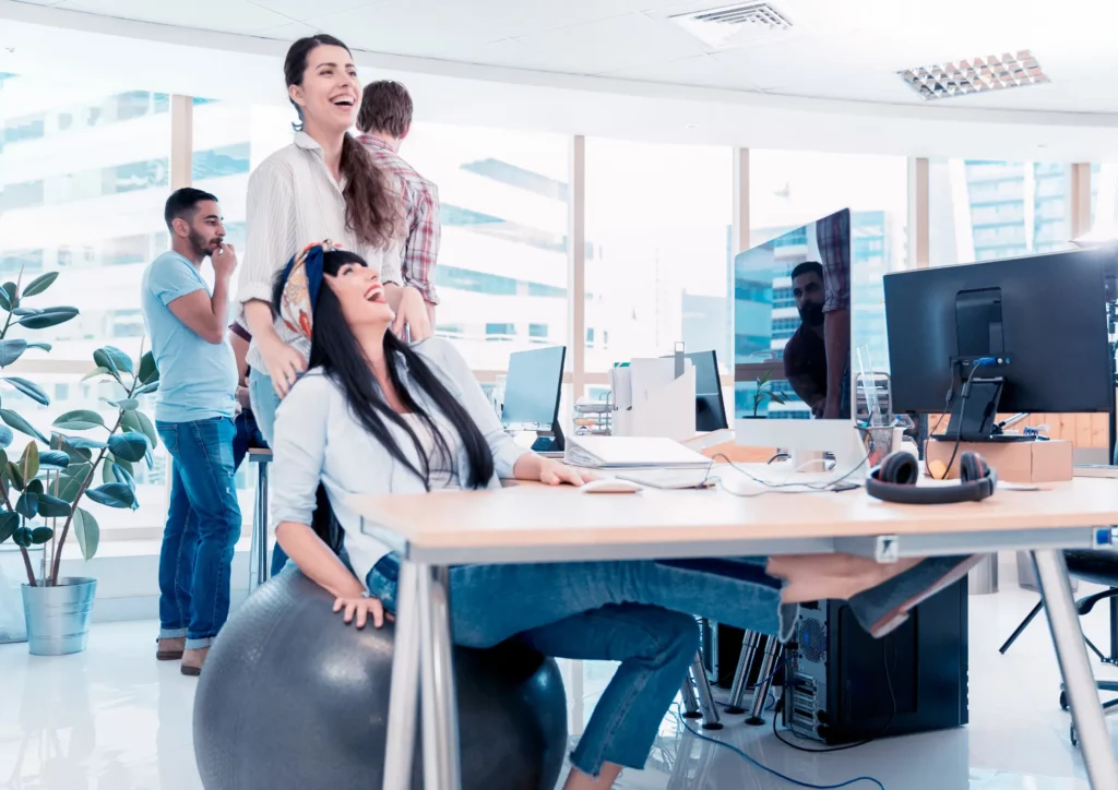 Une groupe de femmes salariées rigolant d'une bonne blague au travail.