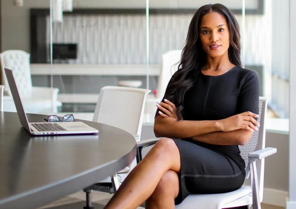 Une femme businesswoman en tailleur assis sur un siège à une table de réunion.