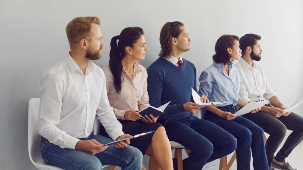 Un groupe de candidats attendant leur tour pour passer un entretien d'embauche.