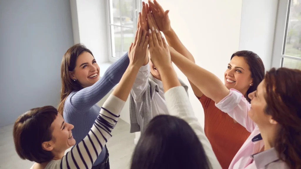 Un groupe d'entraide et de cohésion entre entrepreneurs qui se tapent tous ensemble dans la mains.