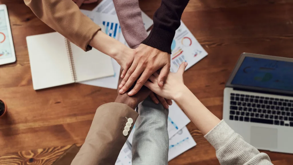 Groupe de personnes soudées joignant leur mains ensemble.